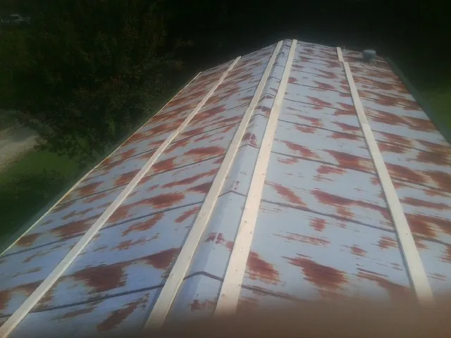 Rusted metal roof panels with new wood purlins before replacement — Storm Damage Roof Repair in Ledbetter by Roofing Brothers