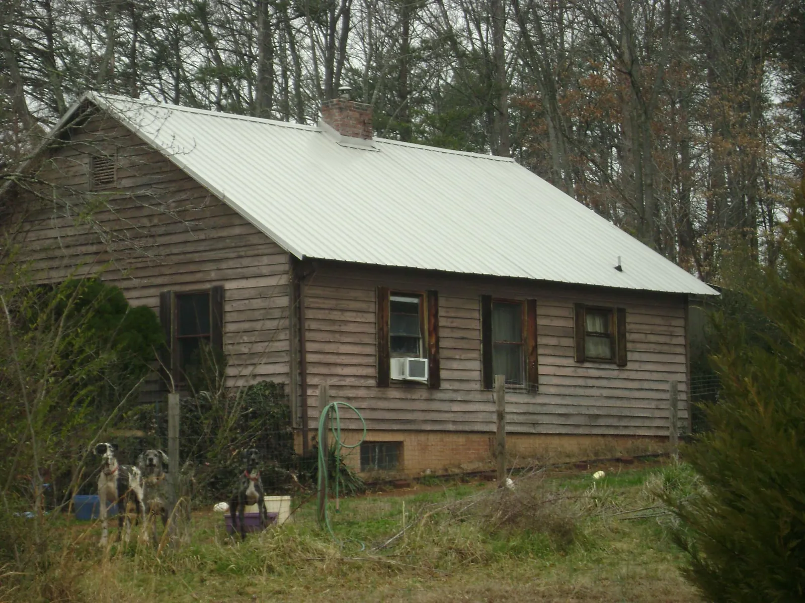 White metal roof on an old wood sided farmhouse, from a Asphalt Shingle Roof Repair job in Ledbetter